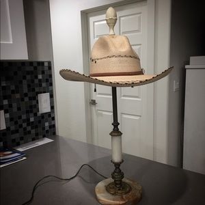 Antique lamp with antique cowboy hat shade.